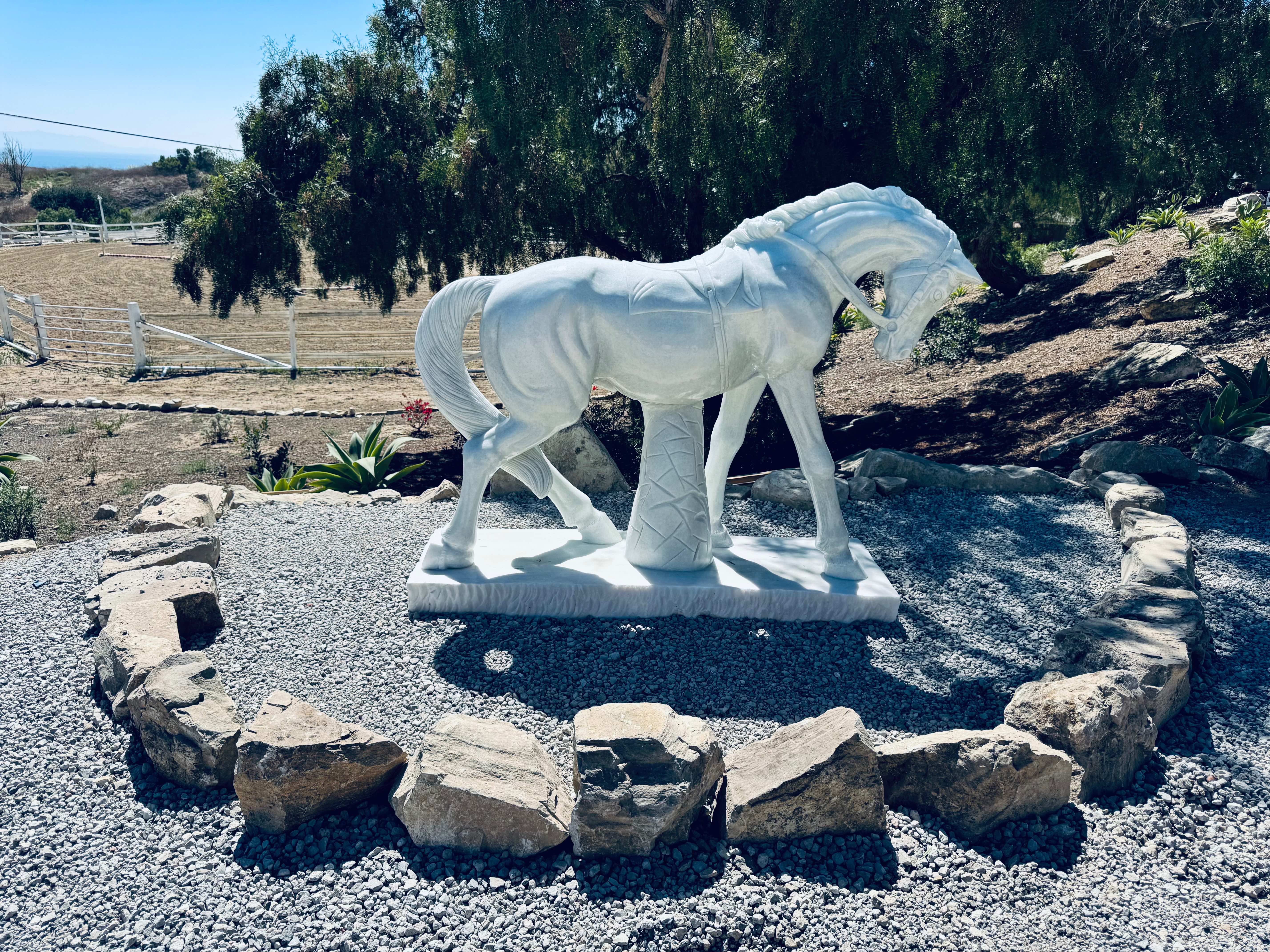 White marble horse sculpture surrounded by stone circle