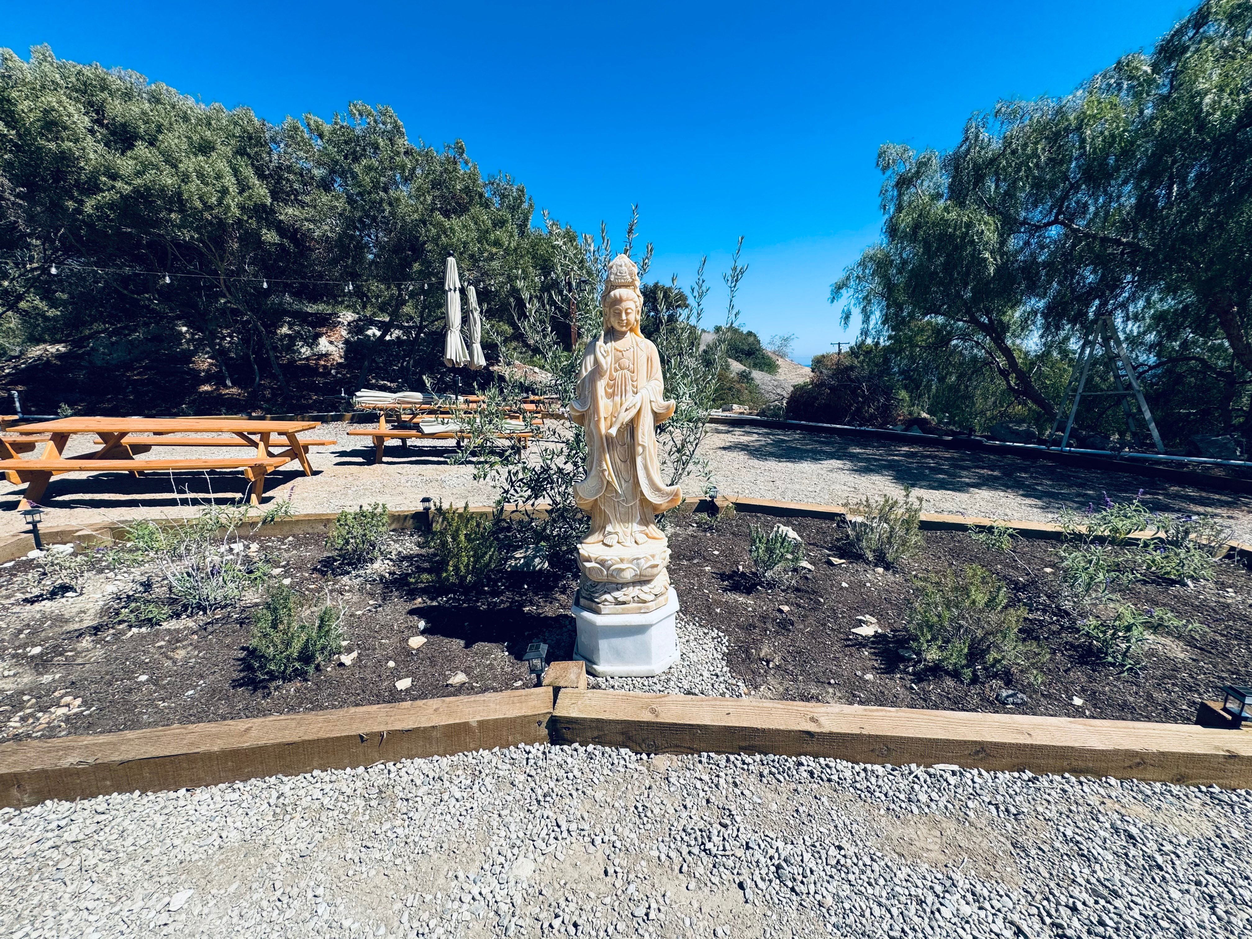 Quan Yin statue in meditation garden with native landscaping