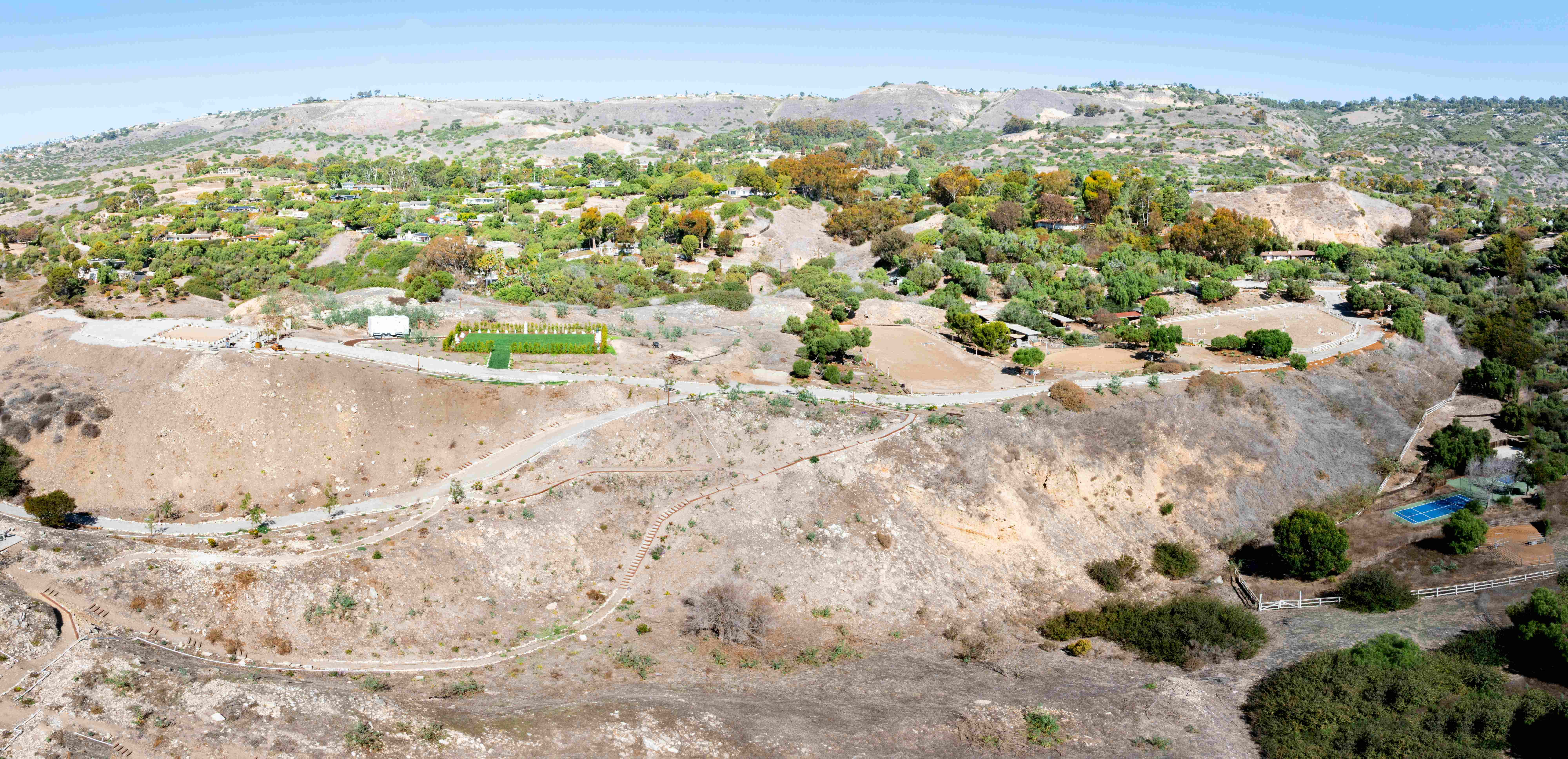 Wide-angle aerial panorama showing Infinite Hill property with Plaza Sunshine, winding trails, and Palos Verdes residential hillsides