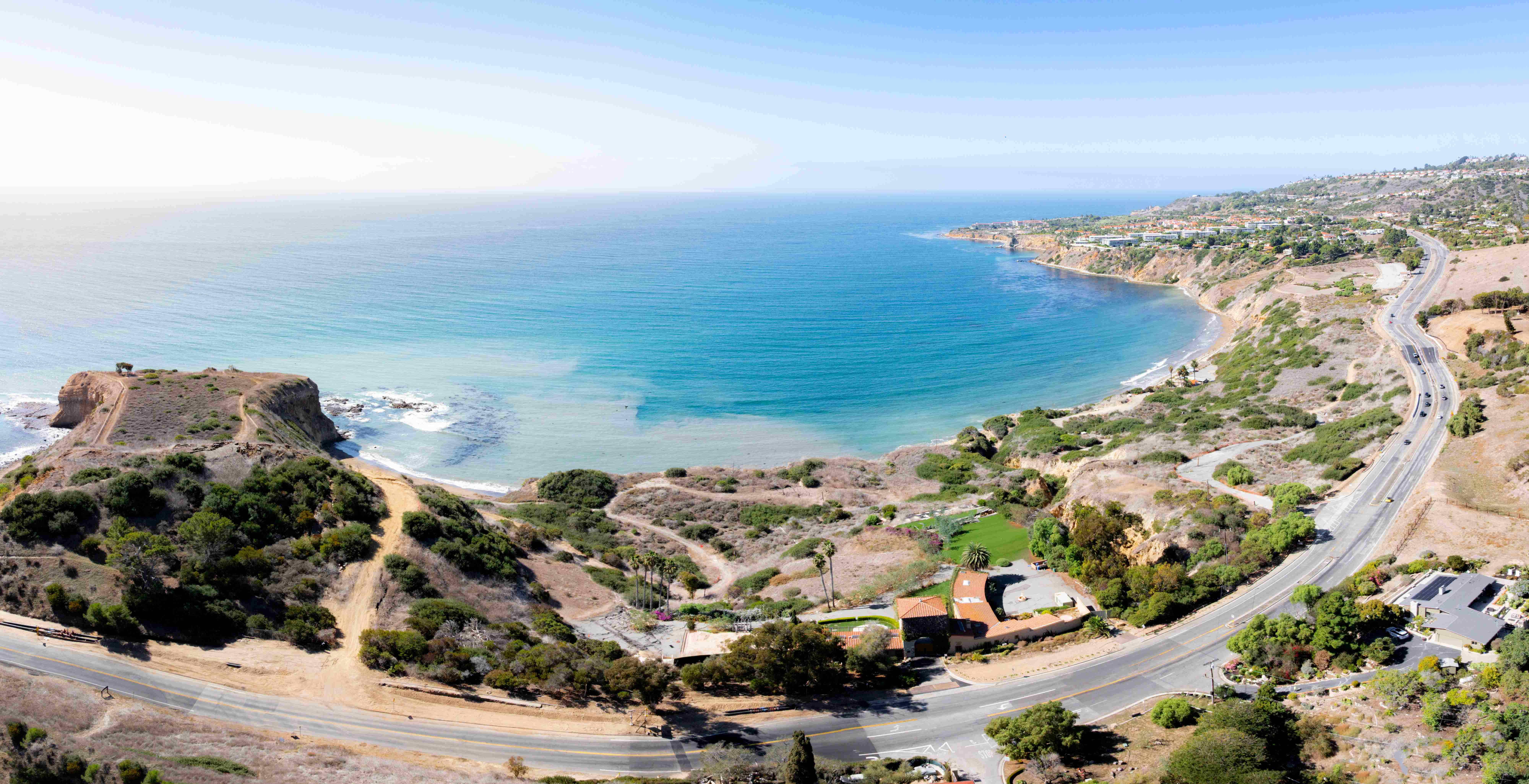 Stunning aerial panoramic view of Palos Verdes coastline with turquoise bay, rocky promontory, and Pacific Coast Highway